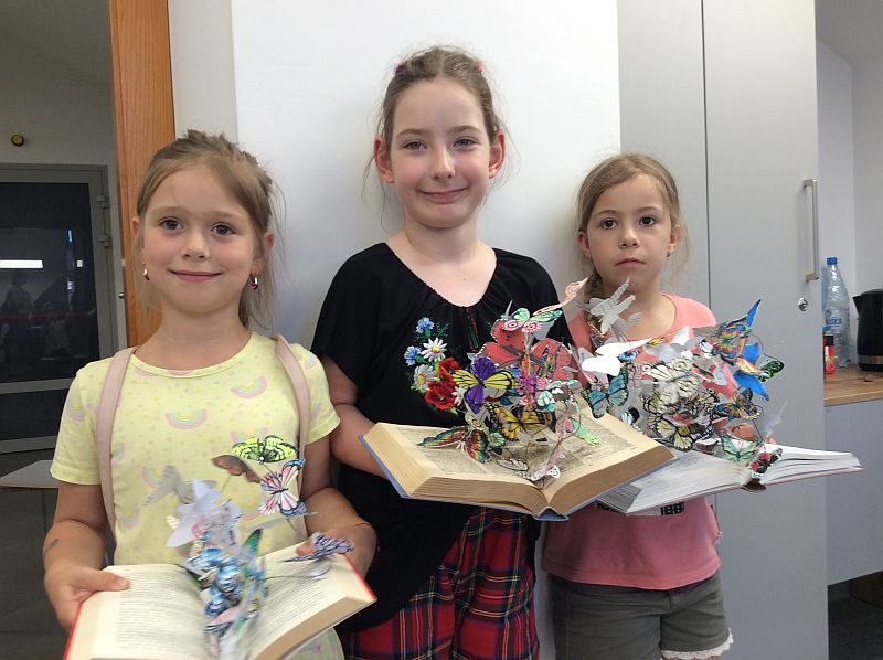 Zdjęcie przedstawia trzy dziewczynki wraz z ich książkowymi motylami.