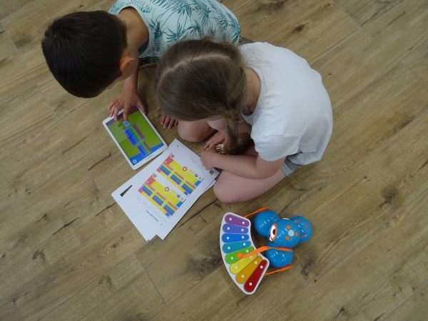 Dwójka dzieci programuje melodię cymbałek dla robota Dash
