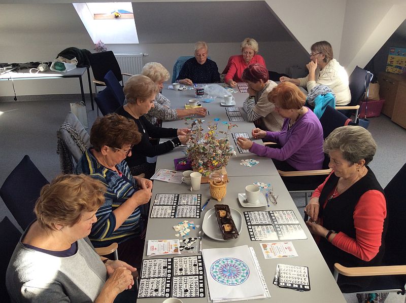 Zdjecie grupowe. Seniorzy graja w bingo.