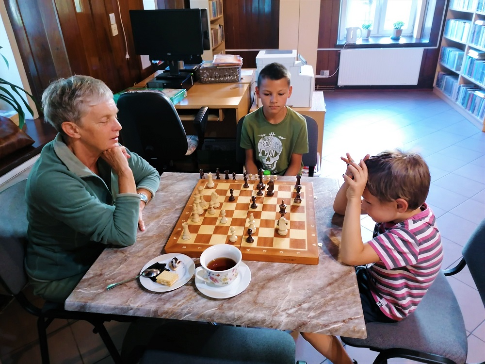 Instruktorka uczy chłopca gry w szachy.