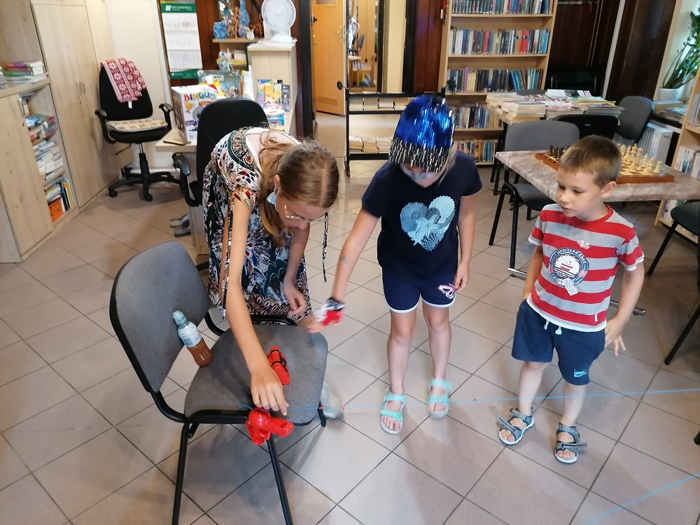 Dzieci w bibliotece grają w Hrono Bomb grę zręcznościową