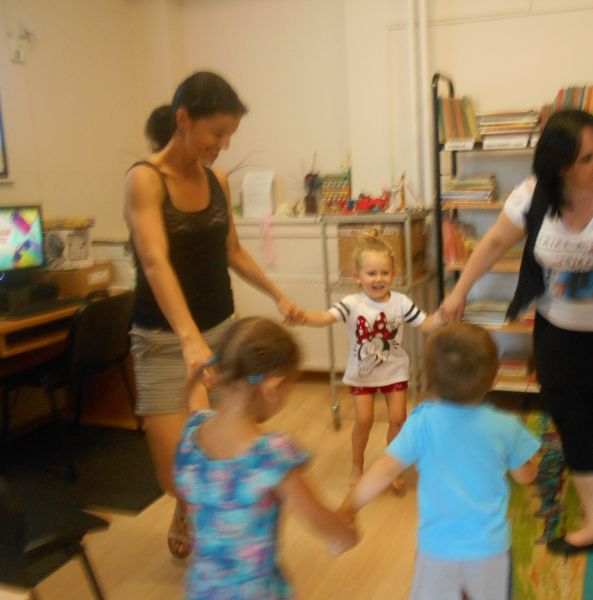 Dzieci z dorosłymi tańczą w kółeczku
