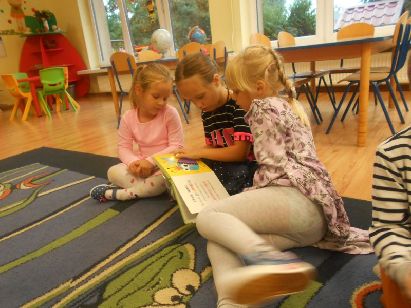 dziewczynki oglądają książeczki