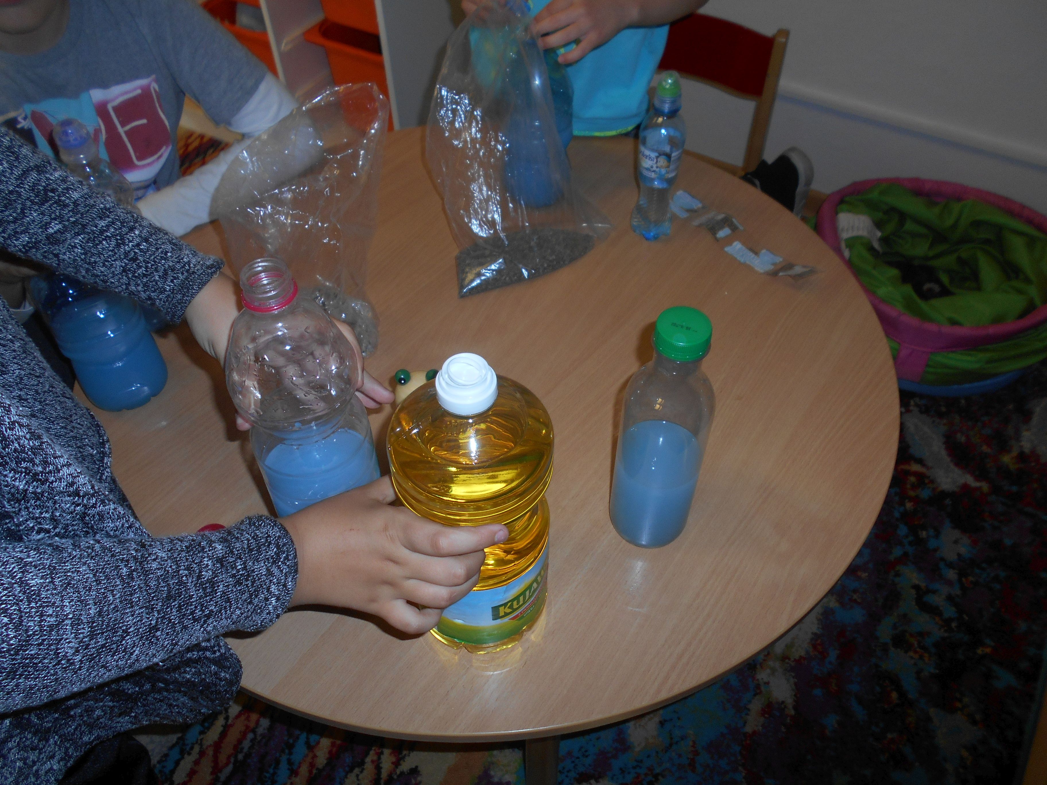 dzieci wlewają olej do wody z barwnikiem 